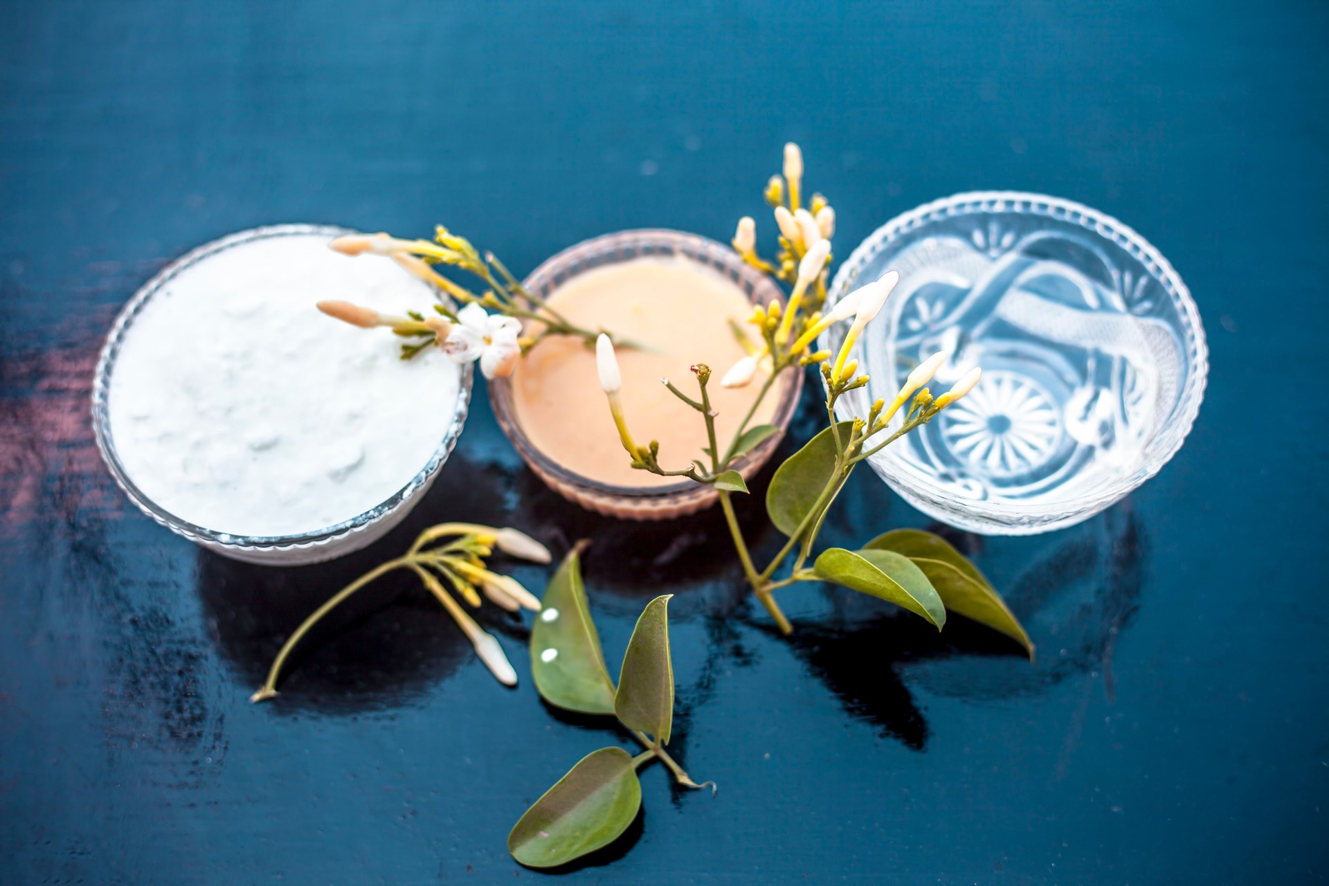 Ayurevidic face pack of Indian jasmine in a glass bowl on wooden surface i.e. jasmine Petals well mixed with milk cream & water. Used for skin whitening purposes.