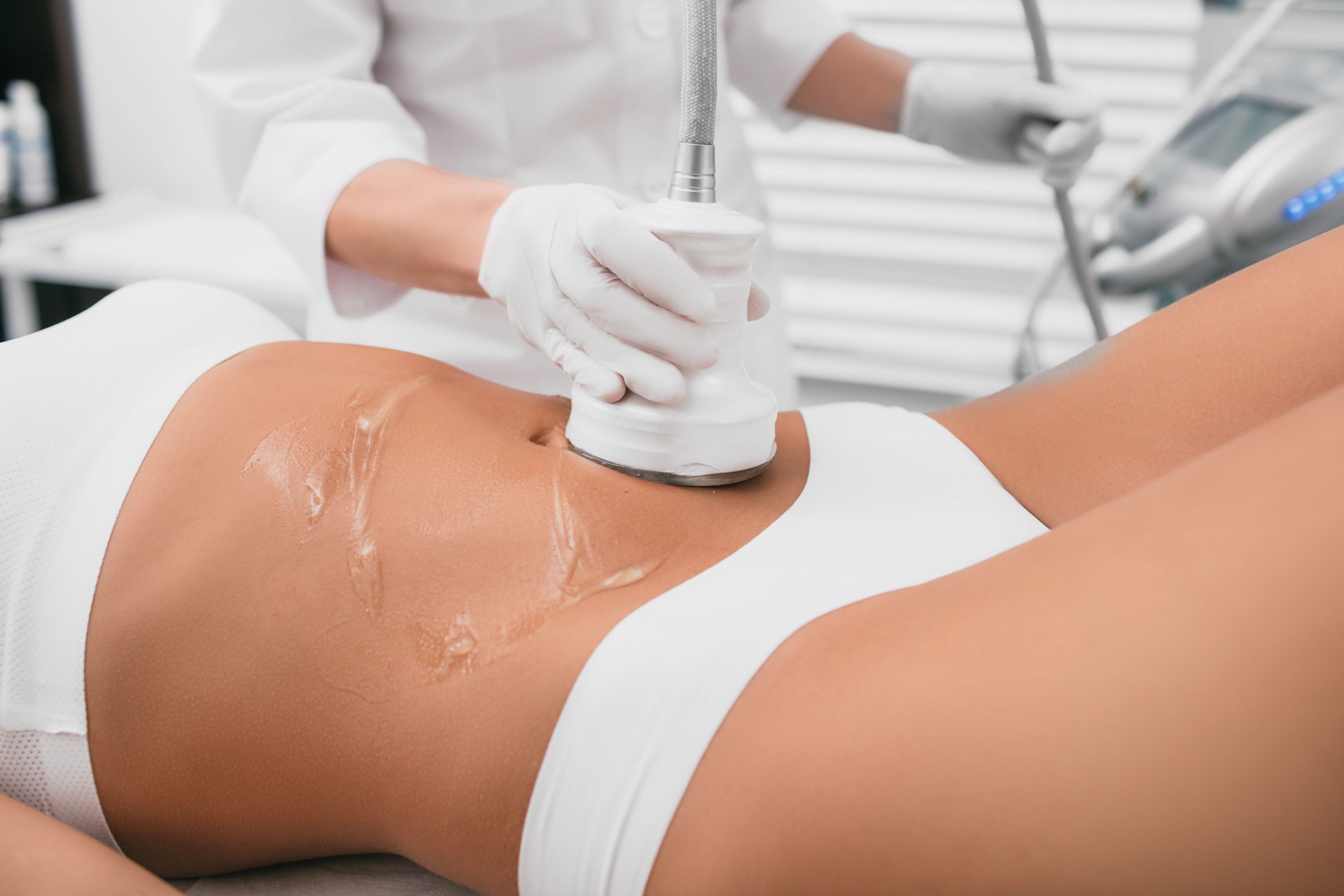 Beautiful woman having cavitation , cellulite treatment, on her belly at beauty clinic