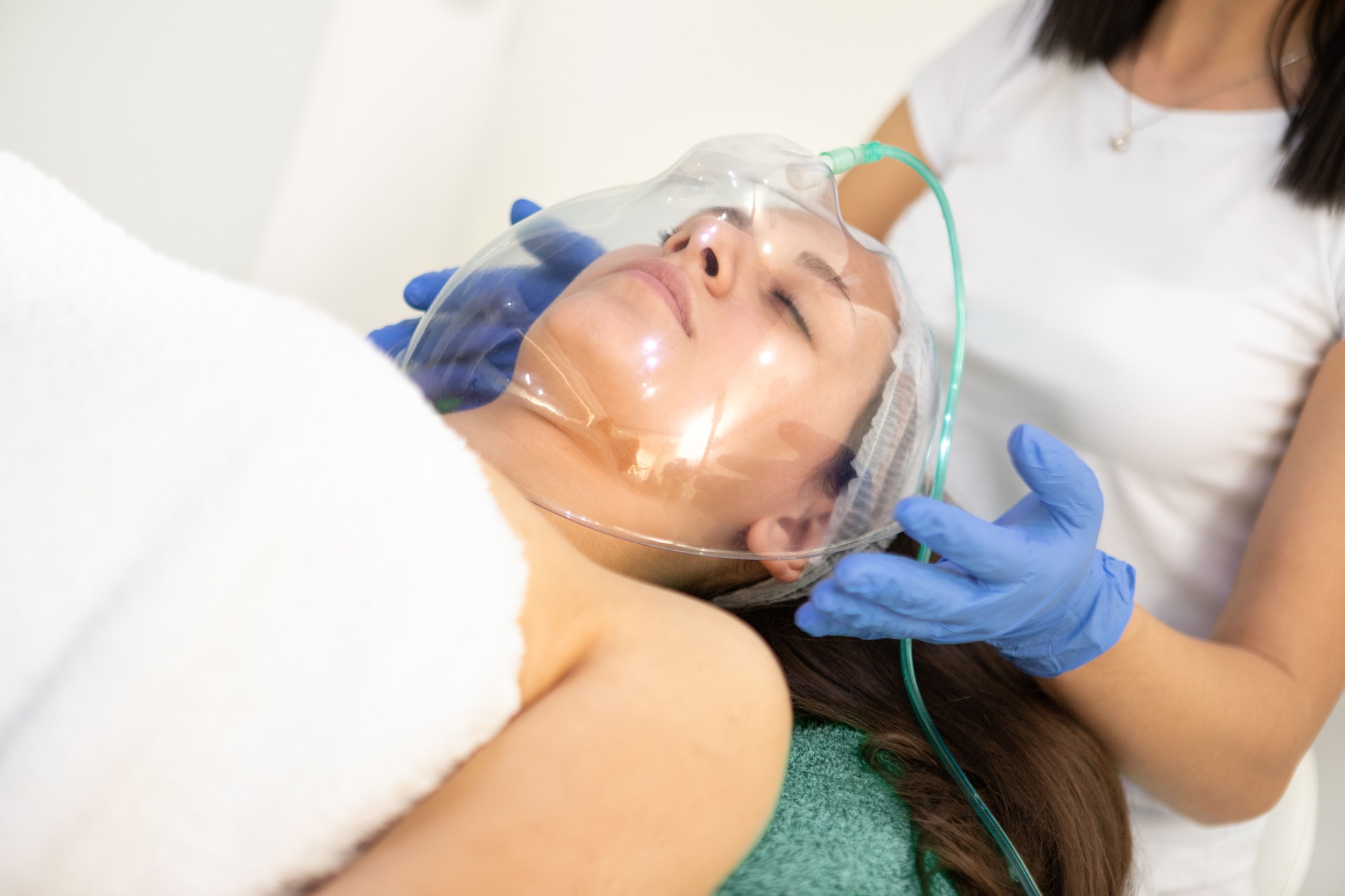 Young woman in cosmetic salon receiving oxy spa face therapy