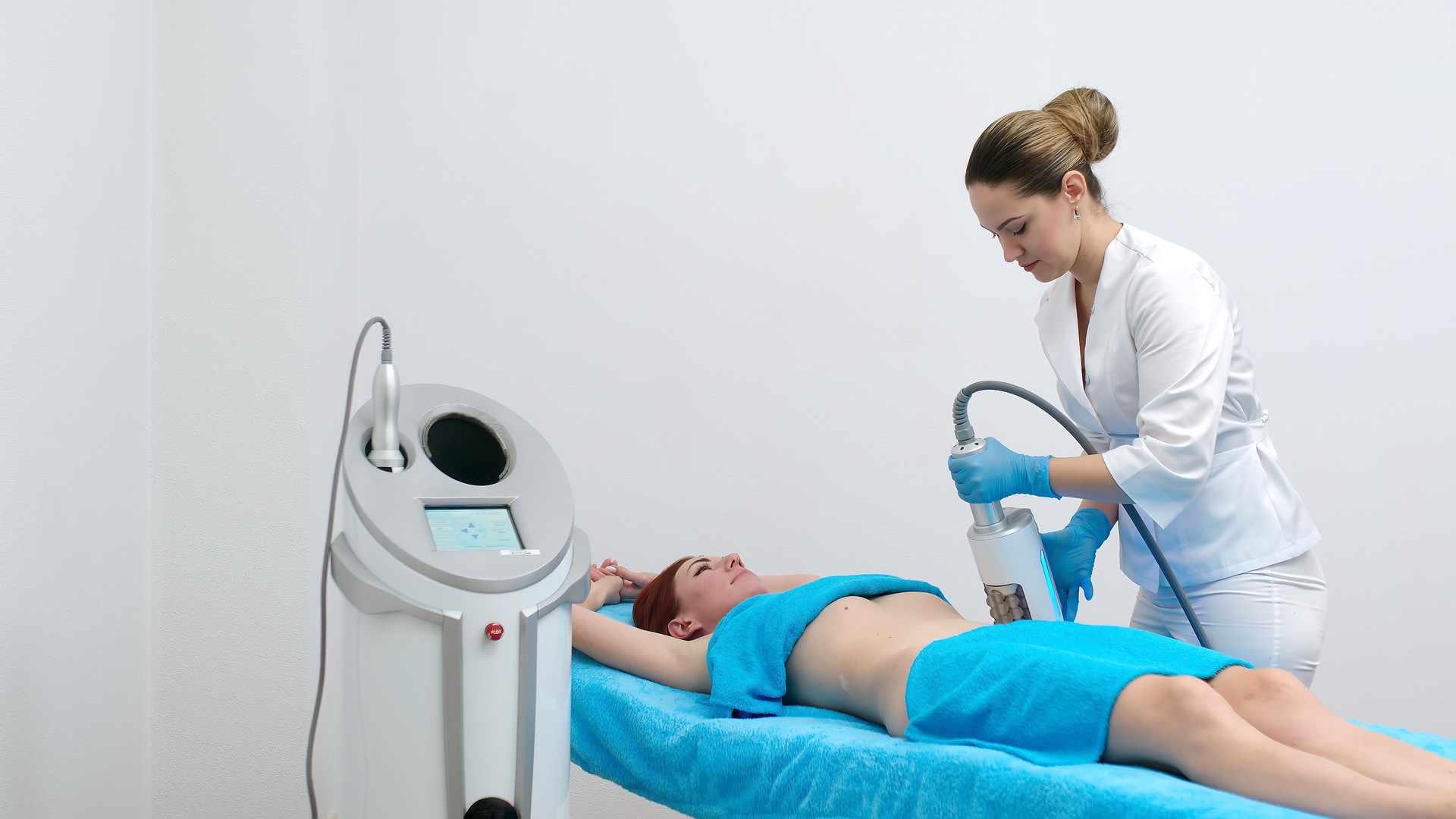 Body shaping and contouring. Close-up of a device massaging the buttocks and body of a young woman. The concept of beauty and body care. A cosmetologist uses an Microvibration Therapy device.
